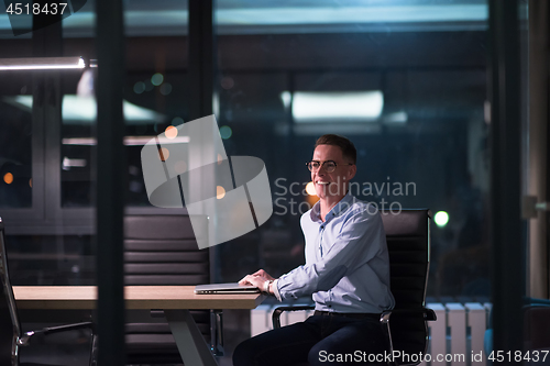 Image of man working on laptop in dark office