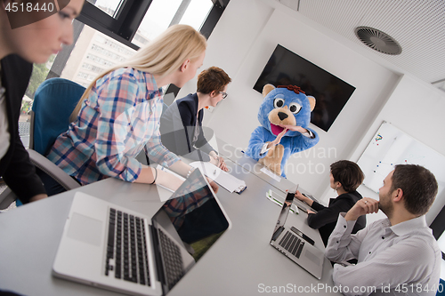 Image of boss dresed as bear having fun with business people in trendy of