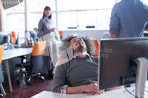 Image of young businessman relaxing at the desk