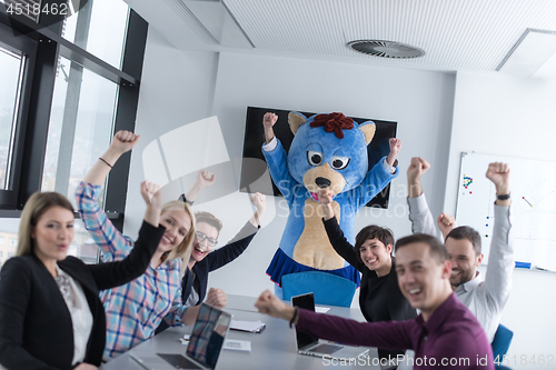 Image of boss dresed as bear having fun with business people in trendy of