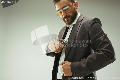 Image of Businessman pulling the gun out of pocket