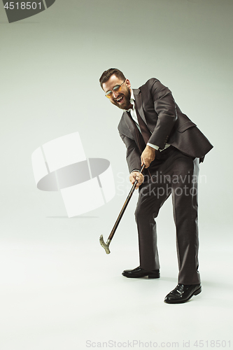 Image of The barded man in a suit holding cane.