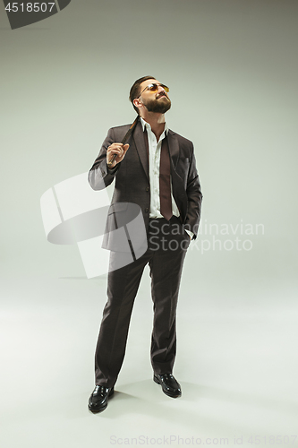 Image of The barded man in a suit holding cane.