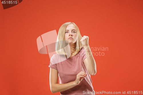 Image of Portrait of an angry woman looking at camera isolated on a red background