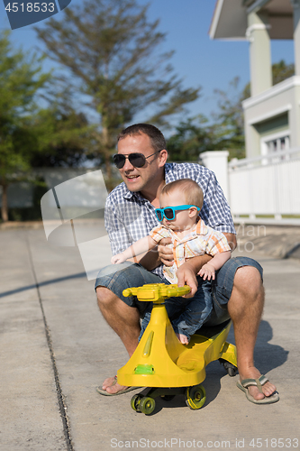 Image of Father and baby son playing on the road at the day time.