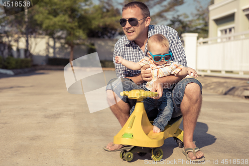 Image of Father and baby son playing on the road at the day time.