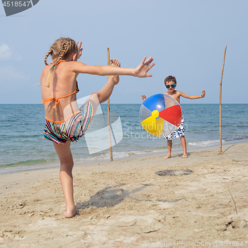 Image of Two happy little children playing on the beach at the day time.