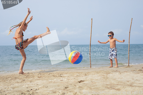 Image of Two happy little children playing on the beach at the day time.