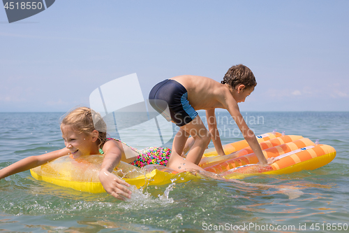 Image of Two happy little children playing on the beach at the day time.