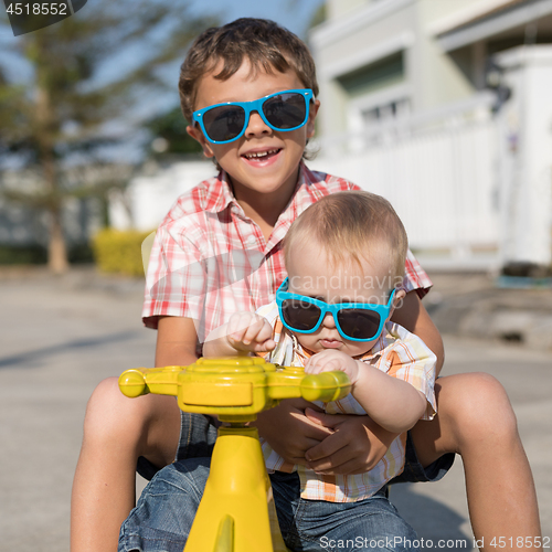 Image of Two happy little children playing on the road at the day time.