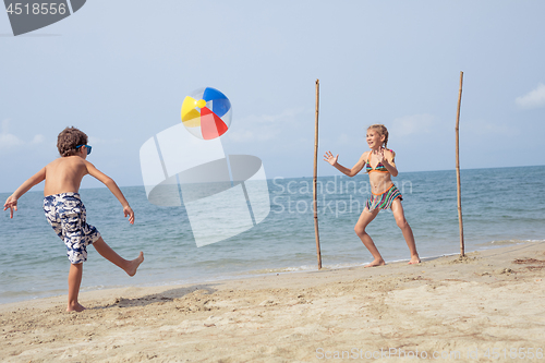 Image of Two happy little children playing on the beach at the day time.