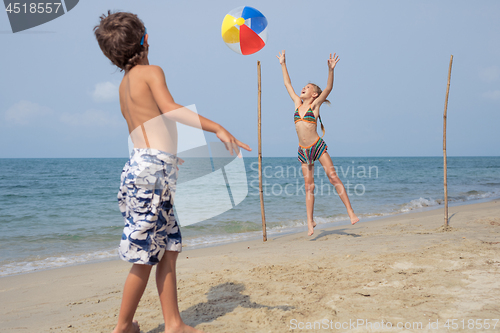 Image of Two happy little children playing on the beach at the day time.