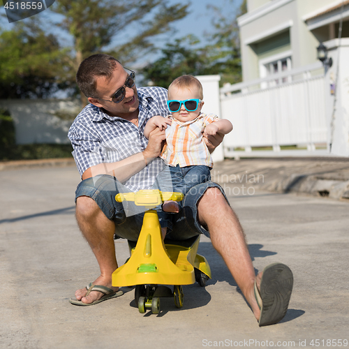 Image of Father and baby son playing on the road at the day time.