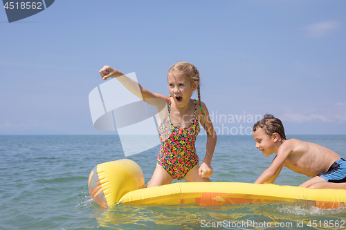 Image of Two happy little children playing on the beach at the day time.