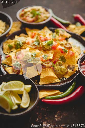 Image of Tasty mexican nachos chips served on ceramic plate