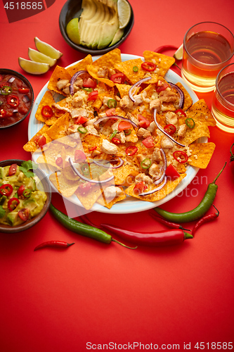 Image of A plate of delicious tortilla nachos with melted cheese sauce, grilled chicken