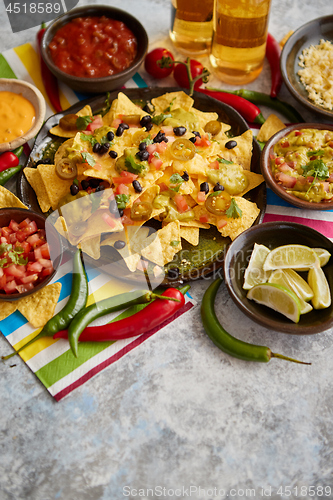 Image of Mexican nachos tortilla chips with black bean, jalapeno, guacamole