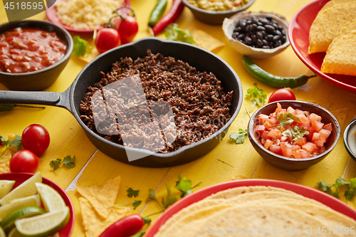 Image of Various fresh and tasty ingredients for chilli con carne. With meat on iron pan