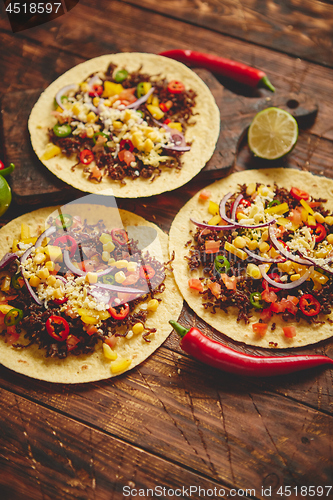 Image of Healthy corn tortillas with grilled beef, fresh hot peppers, cheese, tomatoes