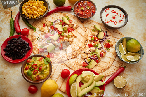 Image of Freshly made healthy corn tortillas with grilled chicken fillet, big avocado slices