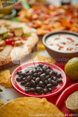 Image of Close up on black beans with various freshly made Mexican foods assortment