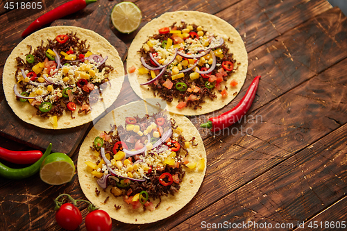 Image of Healthy corn tortillas with grilled beef, fresh hot peppers, cheese, tomatoes