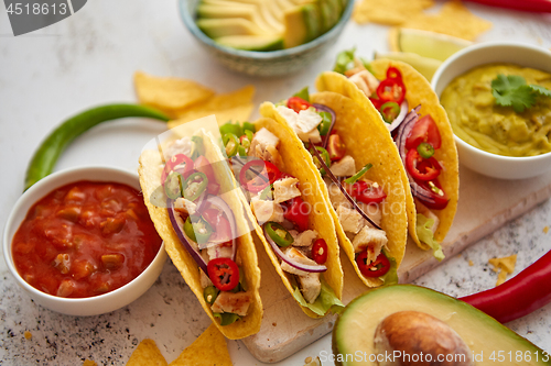 Image of Tasty Mexican meat tacos served with various vegetables and salsa