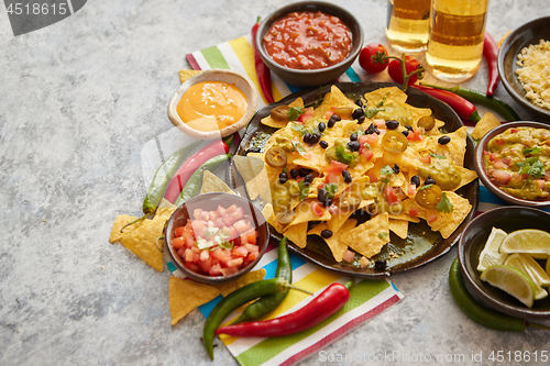 Image of Mexican nachos tortilla chips with black bean, jalapeno, guacamole