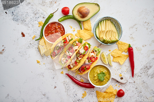 Image of Tasty Mexican meat tacos served with various vegetables and salsa