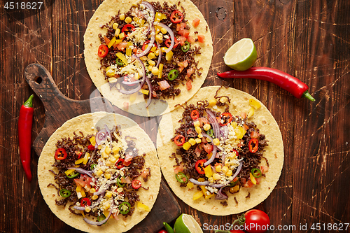 Image of Healthy corn tortillas with grilled beef, fresh hot peppers, cheese, tomatoes