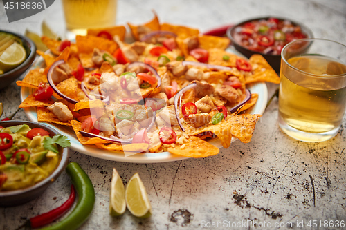 Image of A plate of delicious tortilla nachos with melted cheese sauce, grilled chicken