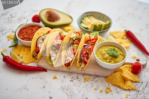 Image of Tasty Mexican meat tacos served with various vegetables and salsa