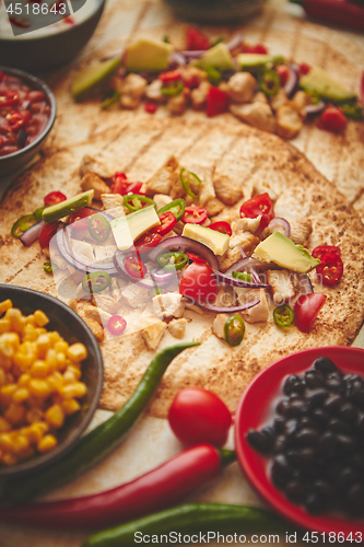 Image of Freshly made healthy corn tortillas with grilled chicken fillet, big avocado slices