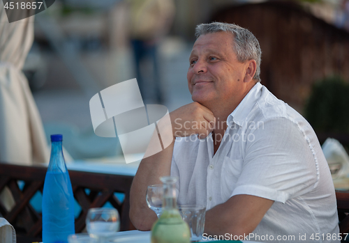 Image of Charming mature man in outdoor cafe