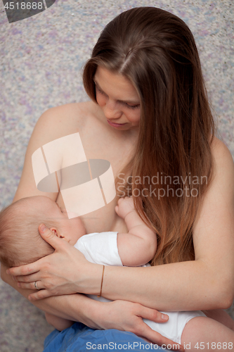 Image of A long haired young woman breastfeeding a baby