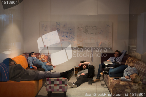 Image of software developers sleeping on sofa in creative startup office