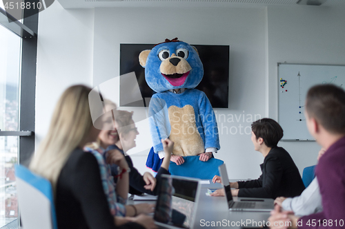 Image of boss dresed as bear having fun with business people in trendy of