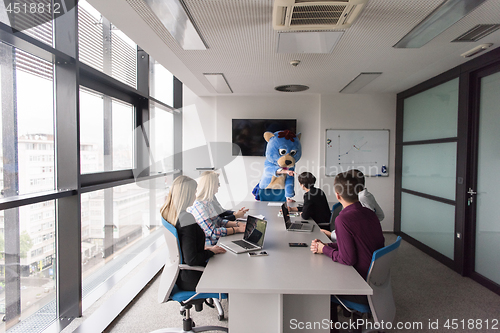 Image of boss dresed as bear having fun with business people in trendy of