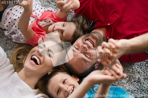 Image of happy family lying on the floor