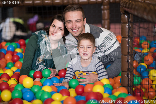 Image of young parents with kids in a children\'s playroom