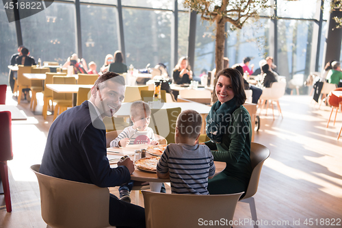 Image of Young parents enjoying lunch time with their children