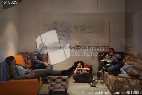 Image of software developers sleeping on sofa in creative startup office