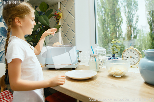 Image of Beautiful girl in her kitchen in the morning preparing breakfast