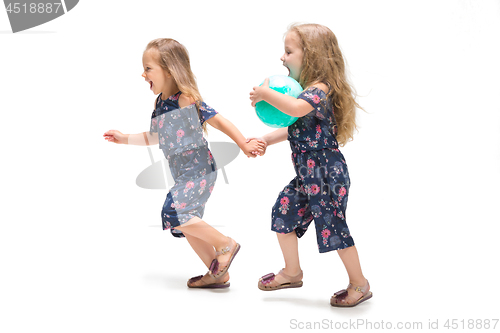 Image of Smiling cute toddler girls three years running over white background