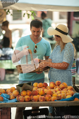 Image of A couple getting peaches at the market