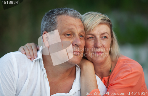 Image of A portrait of a smiling middle aged couple looking into the distance