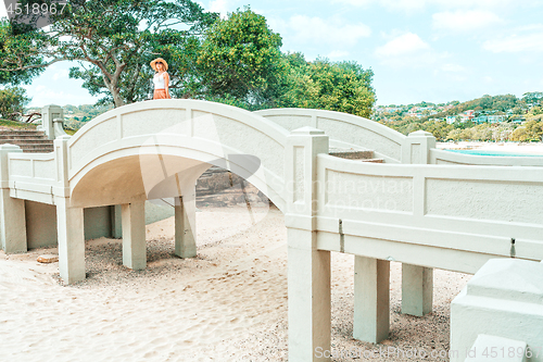 Image of Woman standing on arched bridge at Balmoral Beach