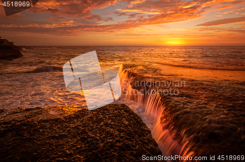 Image of Tidal waterfalls coloured by summer sunrise scenic landscape Australia