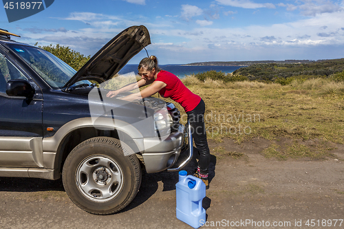 Image of Woman fixing her broken down car 4wd