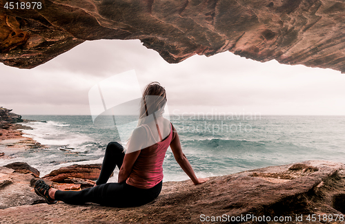 Image of Woman in activewear sitting by the ocean